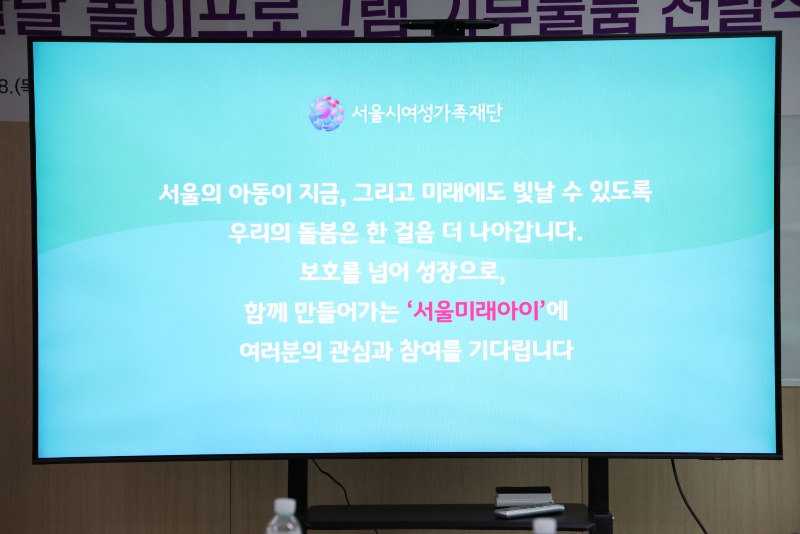 영유아 통합발달을 위한 놀이프로그램 기부물품 전달식을 마무리하는 현장의 안내문 모습 안내문 내용: 서울의 아동이 지금, 그리고 미래에도 빛날 수 있도록 우리의 돌봄은 한 걸음 더 나아갑니다. 보호를 넘어 성장으로, 함께 만들어가는 서울미래아이에 여러분의 관심과 참여를 기다립니다.